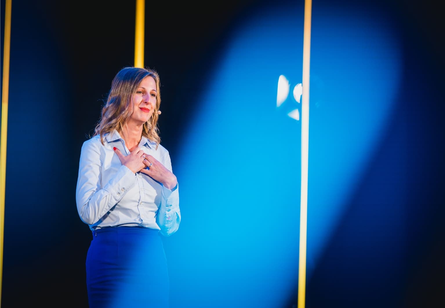 Judith Juhnke speaking on a dark stage